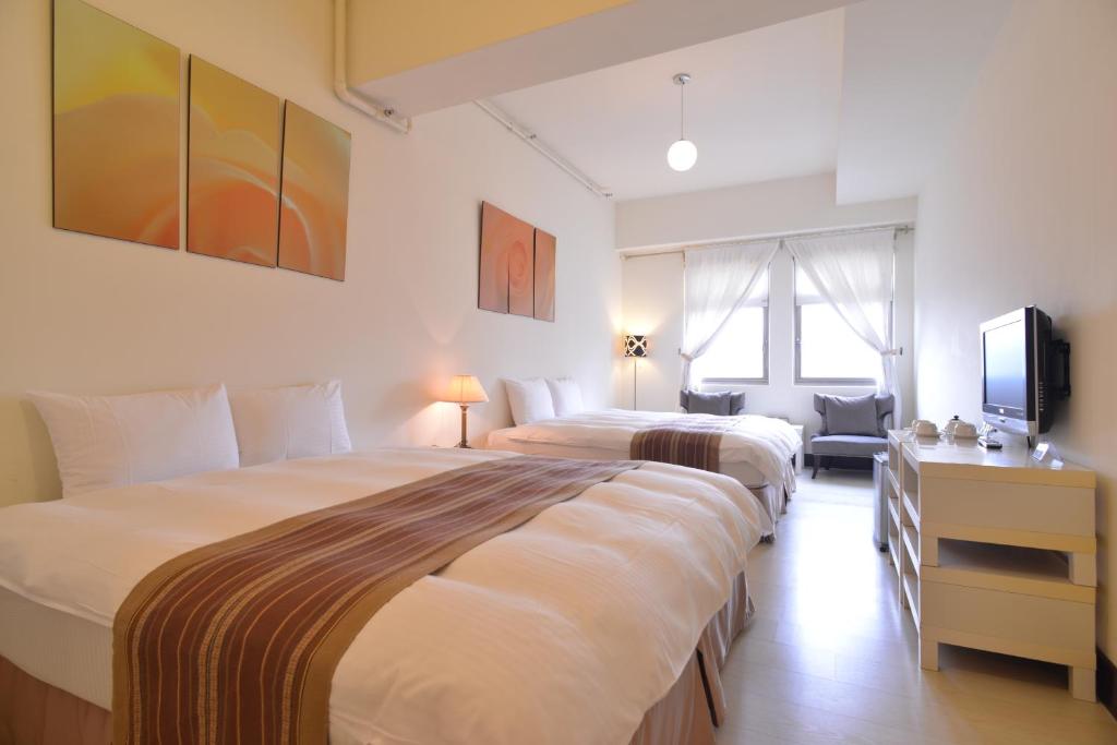 pokój hotelowy z dwoma łóżkami i telewizorem w obiekcie Yago Inn w mieście Tamsui