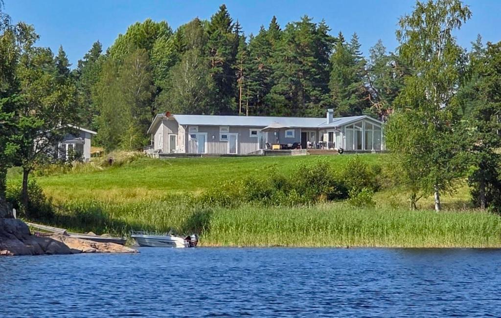 a house sitting on the shore of a lake at 3 Bedroom Beautiful Home In Årjäng in Årjäng