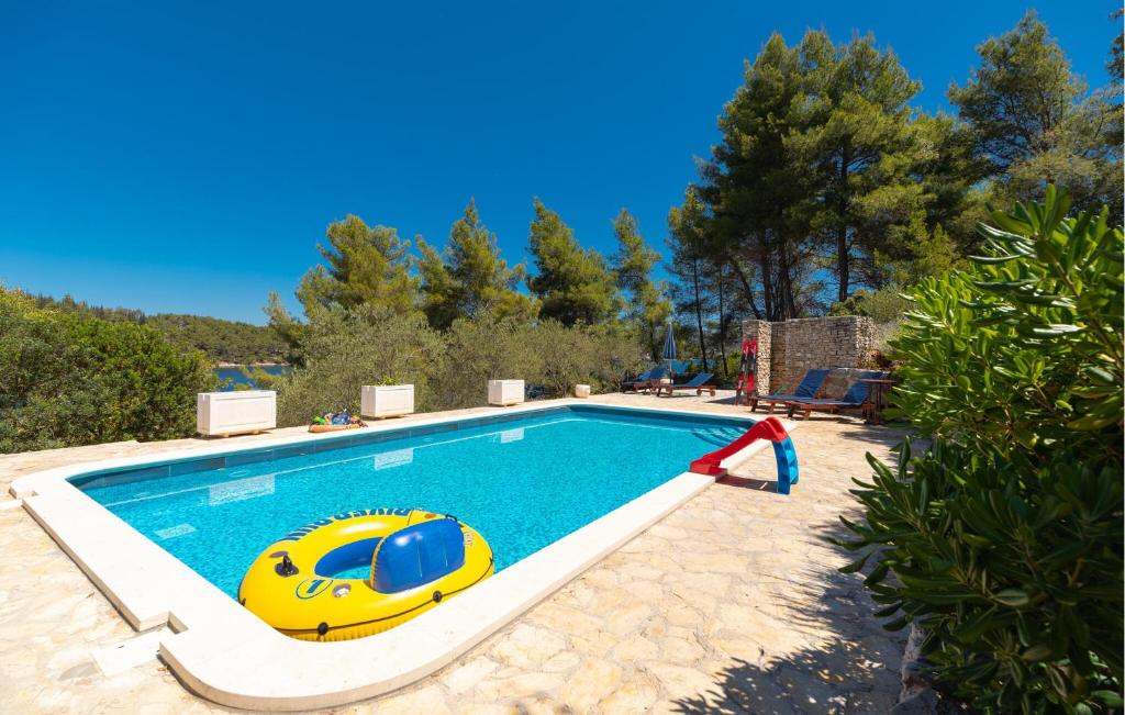 een zwembad met een geel en blauw opblaasbaar bad bij Beautiful Home In Vela Luka in Ostrvo Šijak