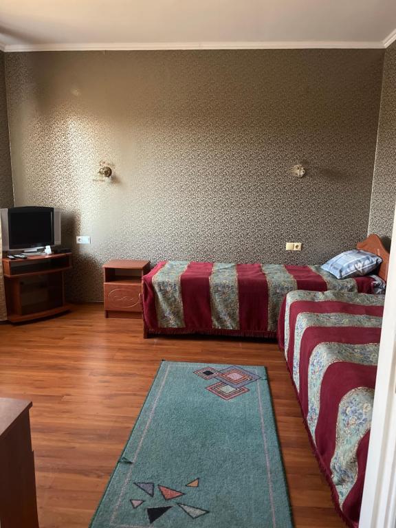 a hotel room with two beds and a rug at Готель Брамка in Kovelʼ