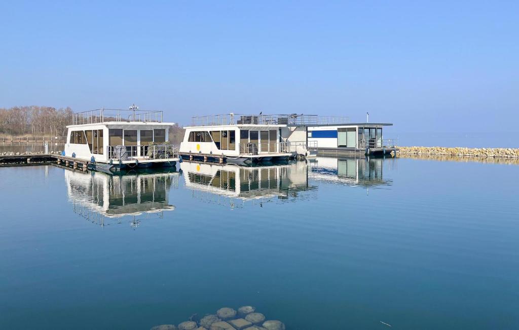 twee boten zijn aangemeerd op een dok in het water bij Haus Boot Sea Breeze in Marienfelde