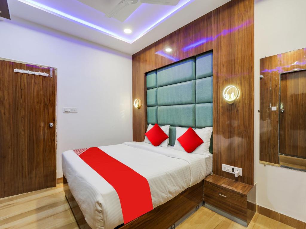 a bedroom with a large bed with red pillows at Super Hotel O bhanu Villa in Ahmedabad