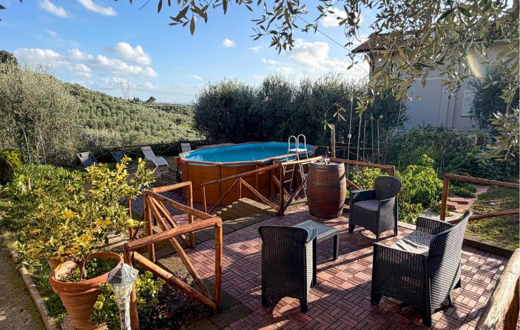 a patio with a swimming pool and some chairs and a table at Pet Friendly Home In Larciano With Swimming Pool in Larciano