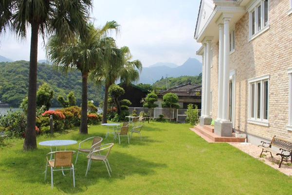 a yard with chairs and tables and a building at La Isla Tasse in Yakushima