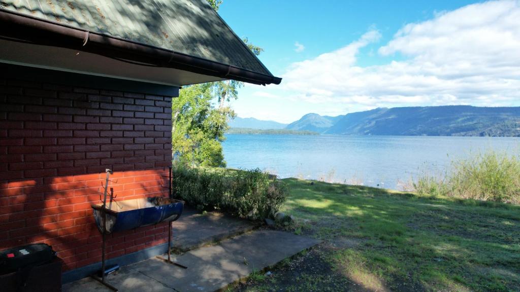 a brick house with a sink on the side of a lake at Cabañas y Domos Calafquen in Coñaripe
