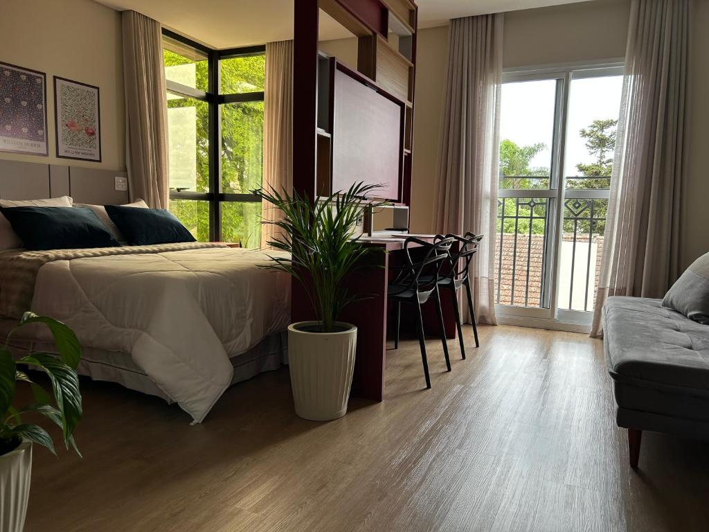 een slaapkamer met een bed en een tafel en een eetkamer bij BetaSuites in Curitiba