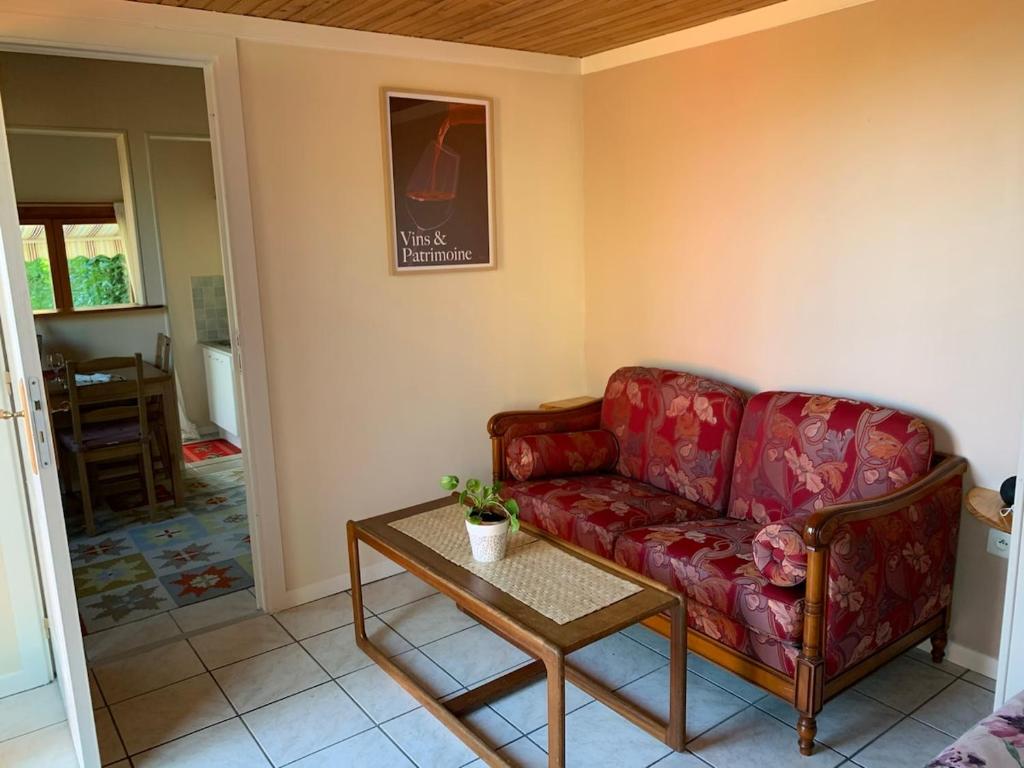 ChâtenetGite - Vin Rose的客厅里有一张红色的沙发和一张桌子