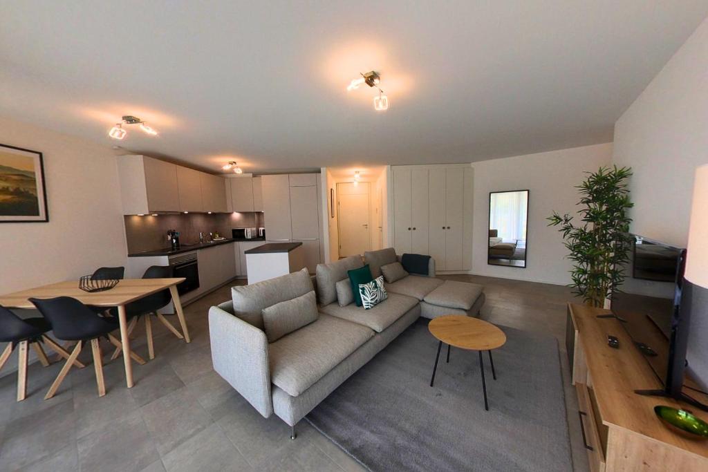 a living room with a couch and a table at Luminous 2-Bed Apartment with Spacious Terrace RSC70-GF in Nyon