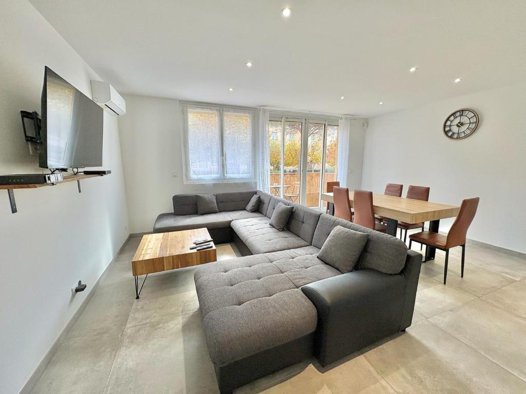 ein Wohnzimmer mit Sofa und Tisch in der Unterkunft Appartement 3 chambres avec terrasse et Parking à Fréjus in Fréjus
