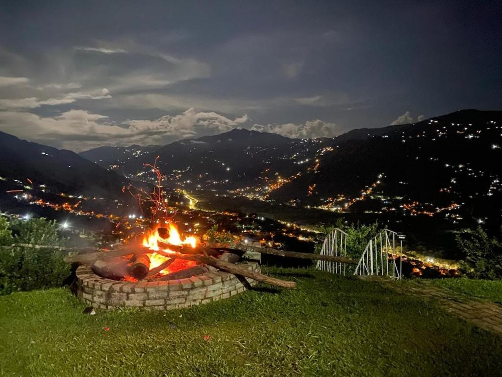 a fire pit on the side of a hill at night at Finca Panoramica in Barbosa