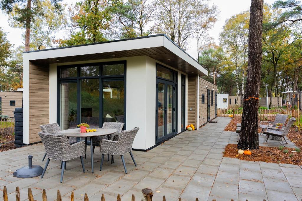 una casa con un patio con mesa y sillas en Chalet Vlinder, en Haarle