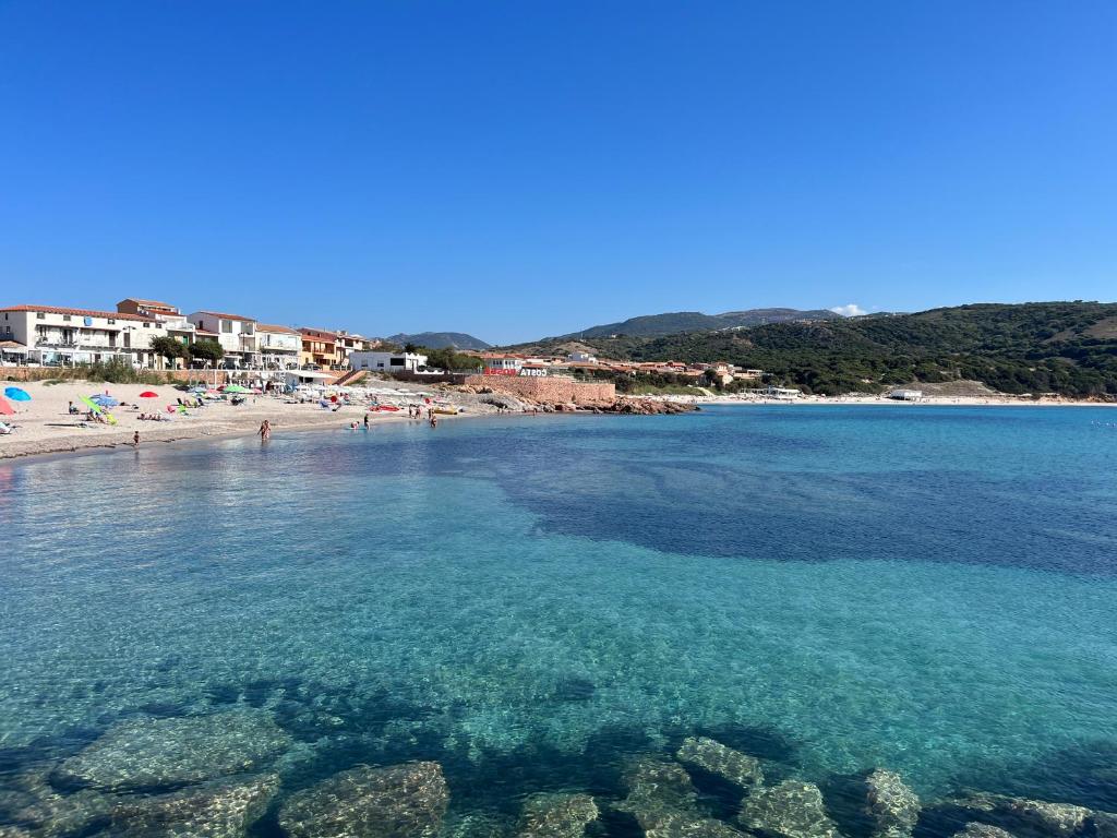 a view of a beach with people in the water at Isola Rossa Appartamenti Comfort plus in Isola Rossa