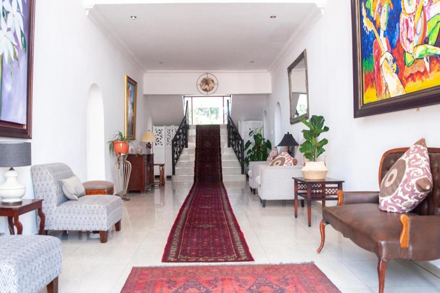 a living room with couches and a rug at Miyanwe in Pretoria