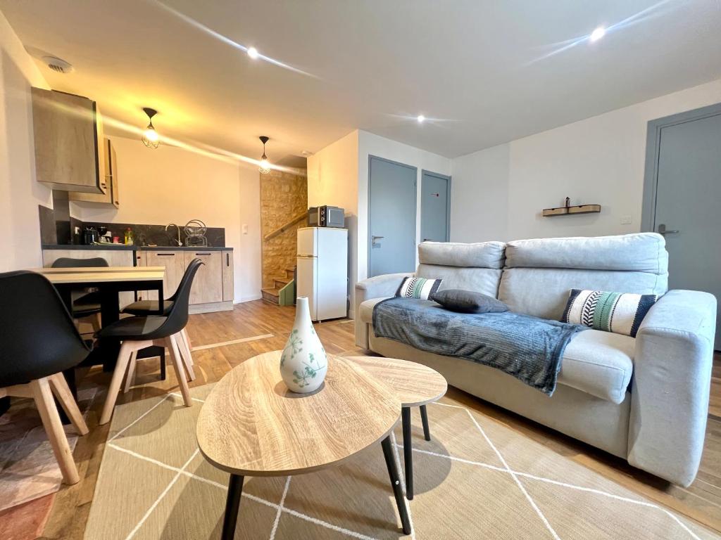 una sala de estar con un sofá y una mesa en Le souvenir Spacieux t2 aux portes du Futuroscope, en Saint-Georges-lès-Baillargeaux