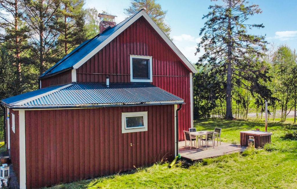 a red barn with a deck and a table at Amazing Home In Bjärtrå With Sauna in Bjärtrå