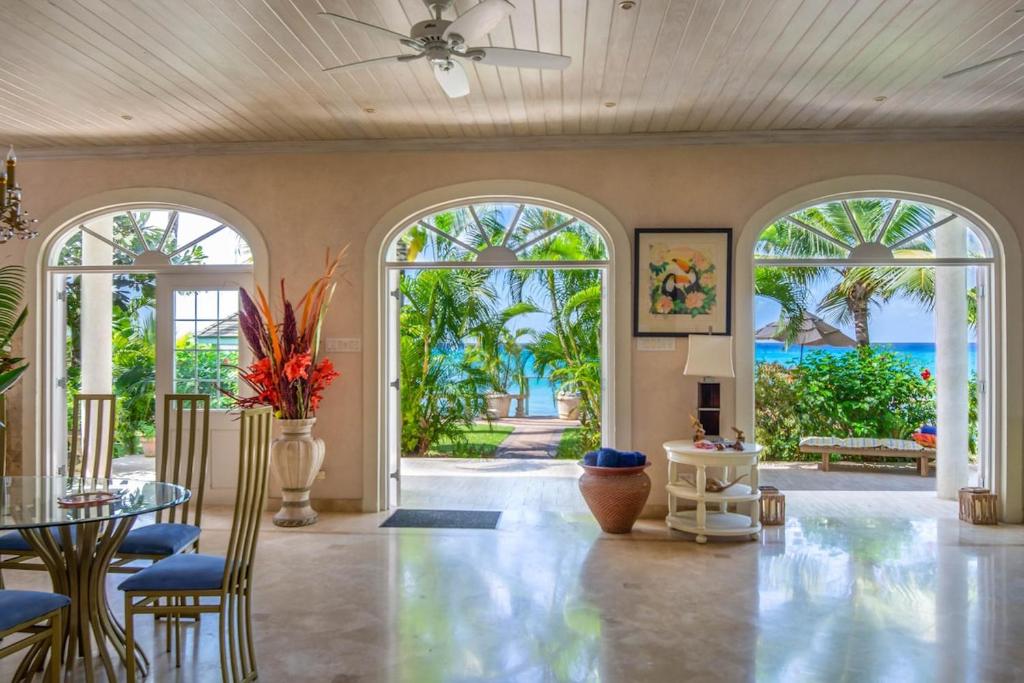 an open living room with large windows and a patio at Ebbtide villa in Saint James