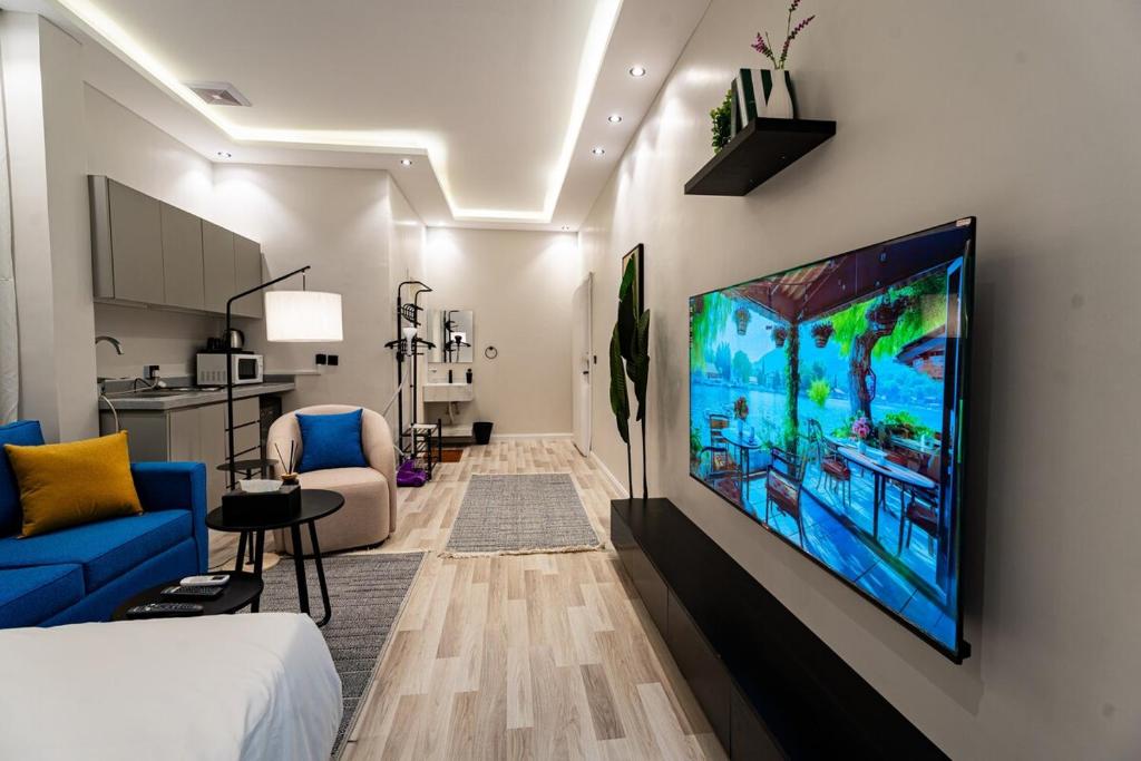a living room with a large television hanging on a wall at A distinctive and upscale studio in Salamanca 112 in Riyadh