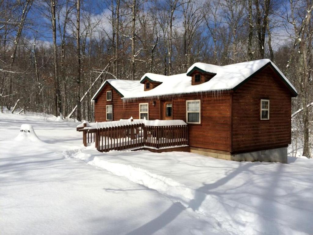 a wooden house in the snow with a fence at Mammoth Cave Accommodation for a Kentucky Glamping Experience in Mammoth Cave