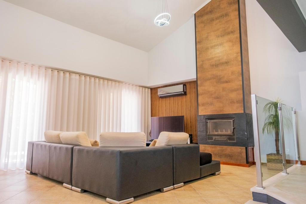 a living room with a couch and a fireplace at Verde Verdilhão Villa 