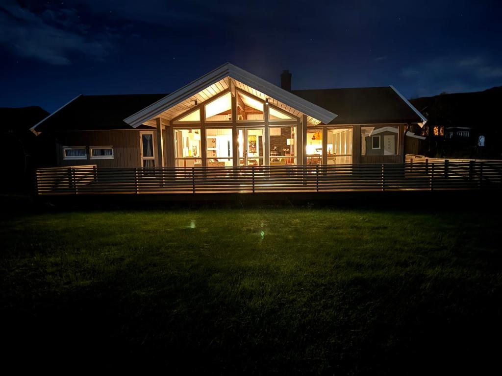 een huis met grote glazen ramen op een tuin 's nachts bij Tromsø idyllic cabin in Tromsø