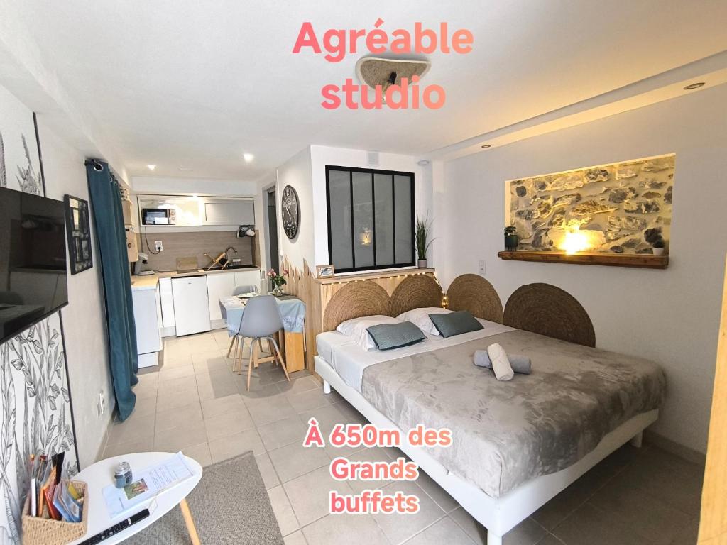 une chambre avec un grand lit et une cuisine dans l'établissement agréable studio, à Narbonne