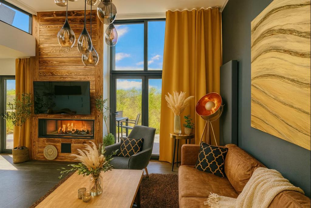 a living room with a couch and a fireplace at Premium-Strand Chalet an der Nordsee - Noordzee - Zeeland in Breskens