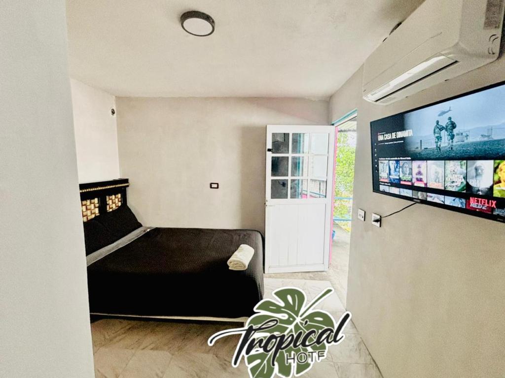 a bedroom with a bed and a flat screen tv at Hotel Tropical in Villahermosa