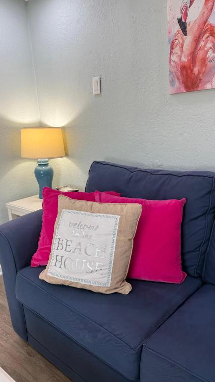 a blue couch with pink pillows in a living room at Tropical Beach Studio Getaway B in Cocoa Beach