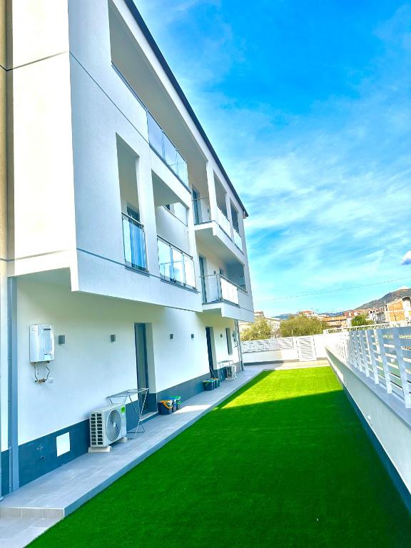 a large white building with a green lawn at Levante Apartments in Torrenova