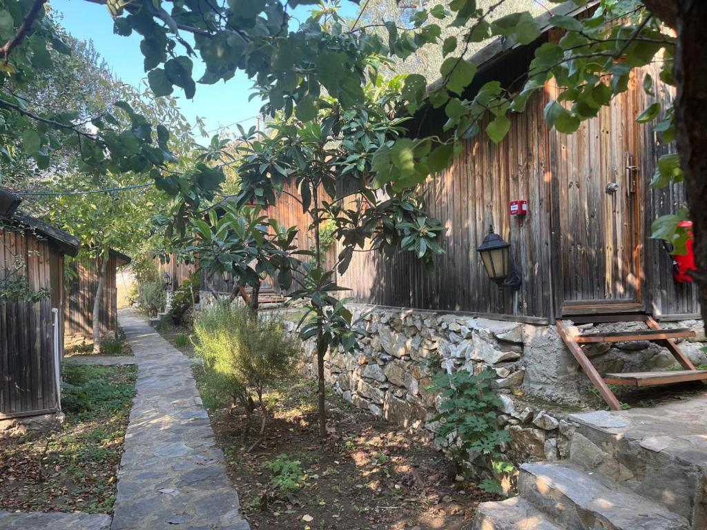 a garden with a fence and a stone path at Kybele Nature Life in Edremit