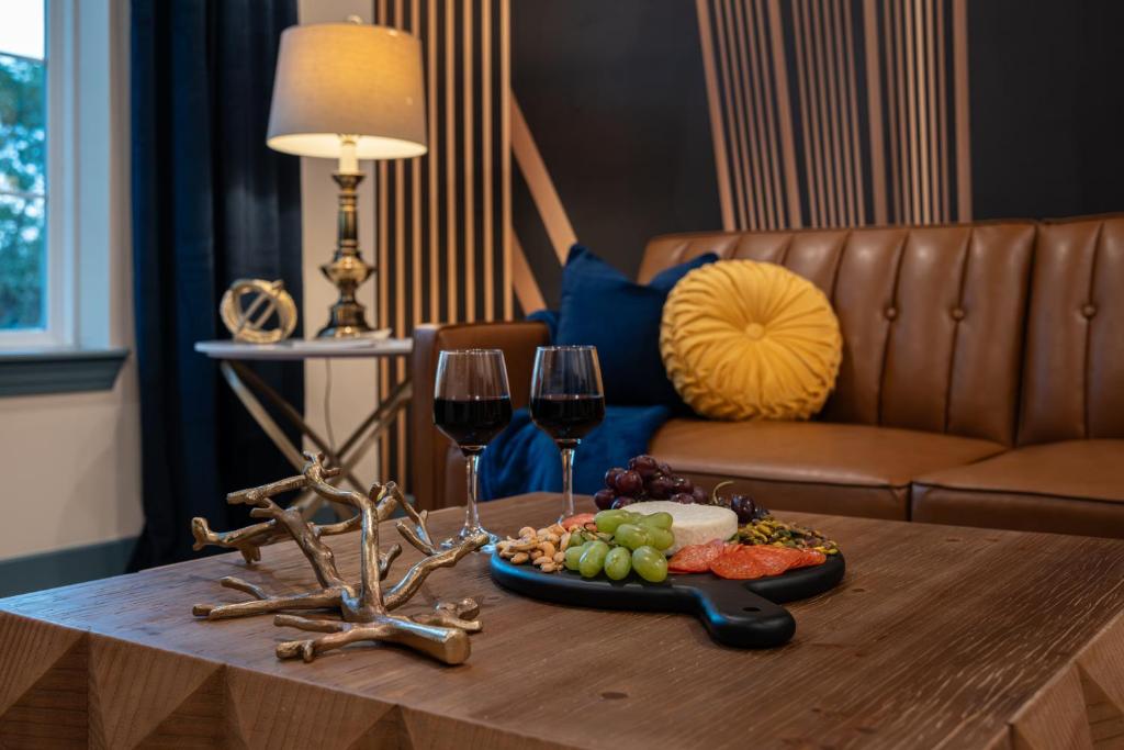 una mesa con una bandeja de comida y dos copas de vino en The Francesca - Apt 333, en Bryan