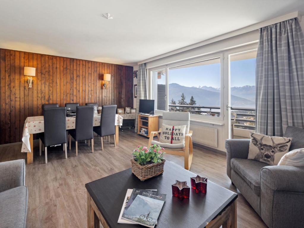 a living room with a table and a large window at Apartment Cransalpin Apt- 11 - Secteur 1 by Interhome in Vermala