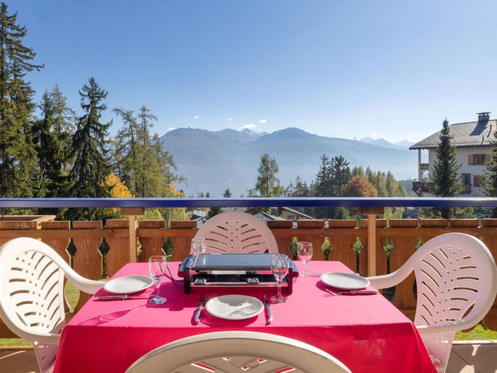 a table with a red table cloth on a balcony at Apartment Résidence Le Chalet 5 by Interhome in Crans-Montana