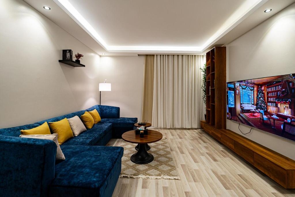 a living room with a blue couch and a tv at Spacious room and hall in Sulaymaniyah 309 in Riyadh