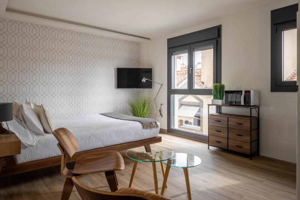 マラガにあるBe Mate Málaga Playaのベッドと椅子とテーブルのある寝室