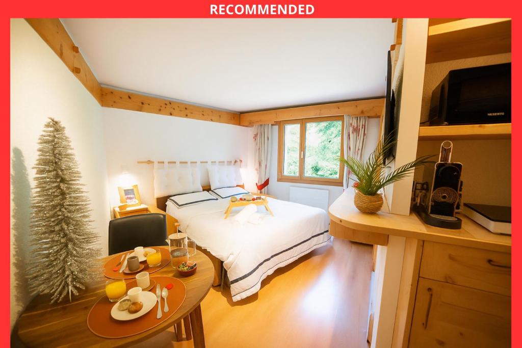 a bedroom with a bed and a table with food on it at Clouds Studio Alpin Luxury Cozy and Pool in Villars-sur-Ollon