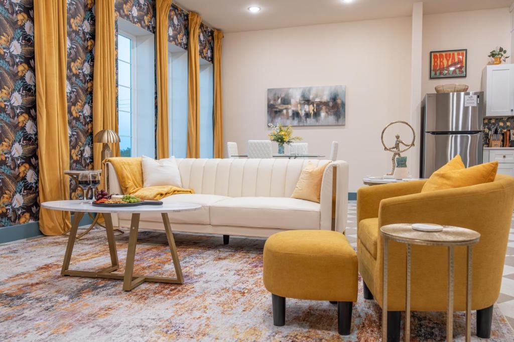 a living room with a white couch and two chairs at The Francesca - Apt 334 in Bryan