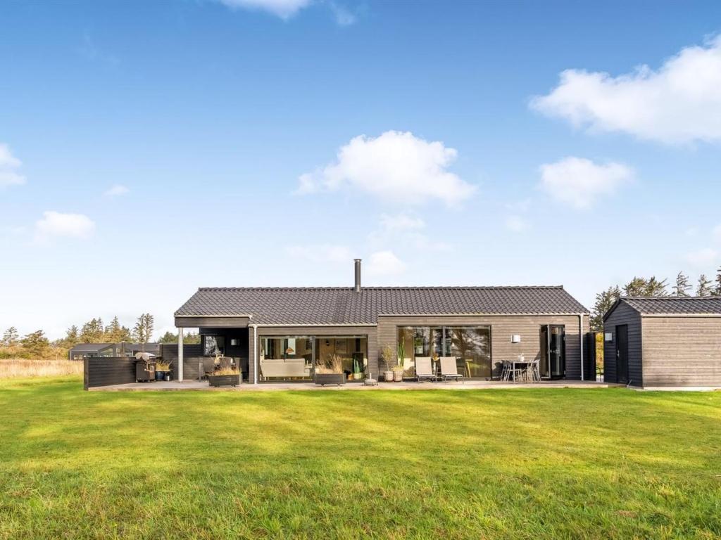 een huis met een grote groene tuin bij Holiday Home Talitha - 1-5km from the sea by Interhome in Hjørring