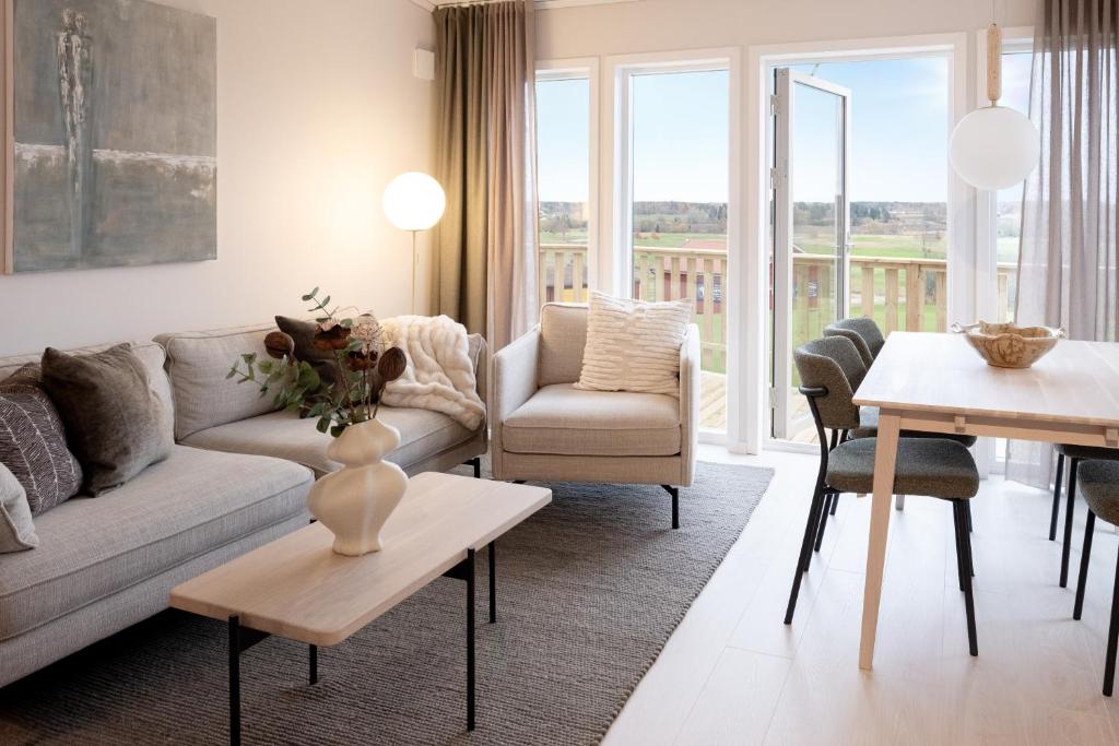 uma sala de estar com um sofá e uma mesa em Skerike Golfhus em Västerås