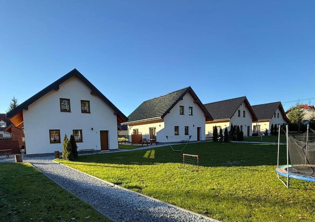 un grupo de casas con un patio con una red en Domki Urbaczka w Istebnej, en Istebna