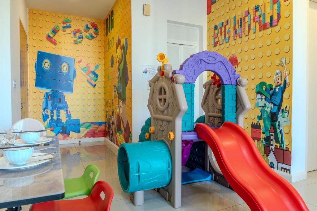 uma sala de jogos para crianças com um conjunto de jogos e um escorrega em D'Pristine Theme Suite by Nest Home at LEGOLAND em Nusajaya