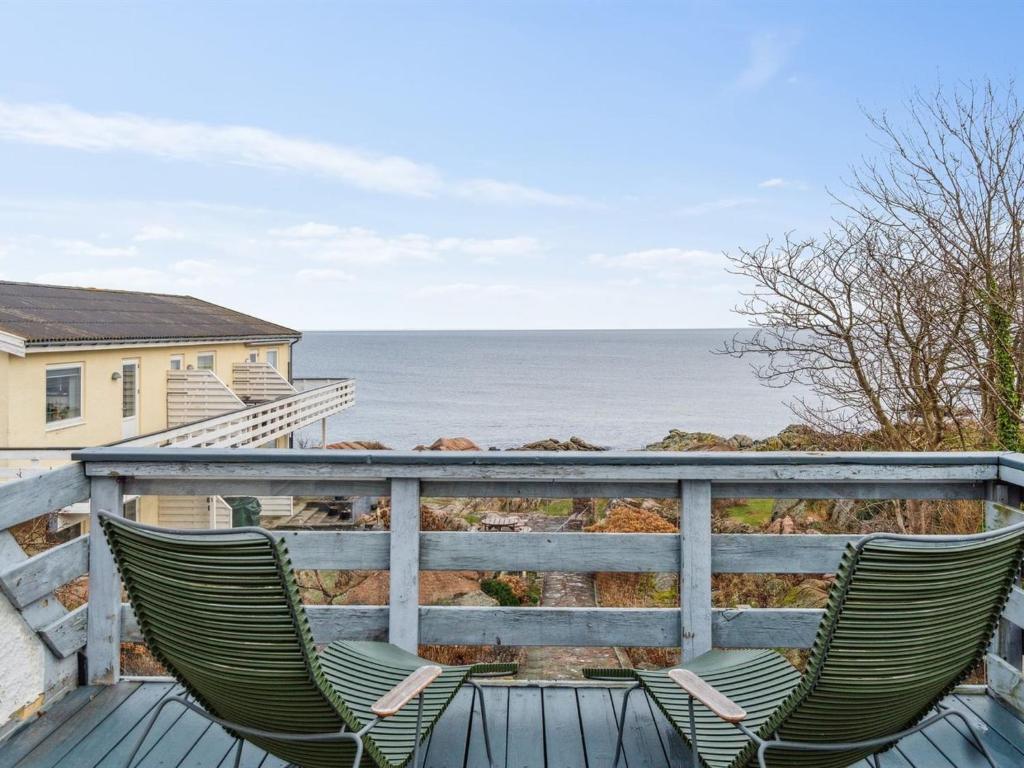 a pair of chairs sitting on a deck overlooking the ocean at Apartment Drude - 50m from the sea by Interhome in Allinge