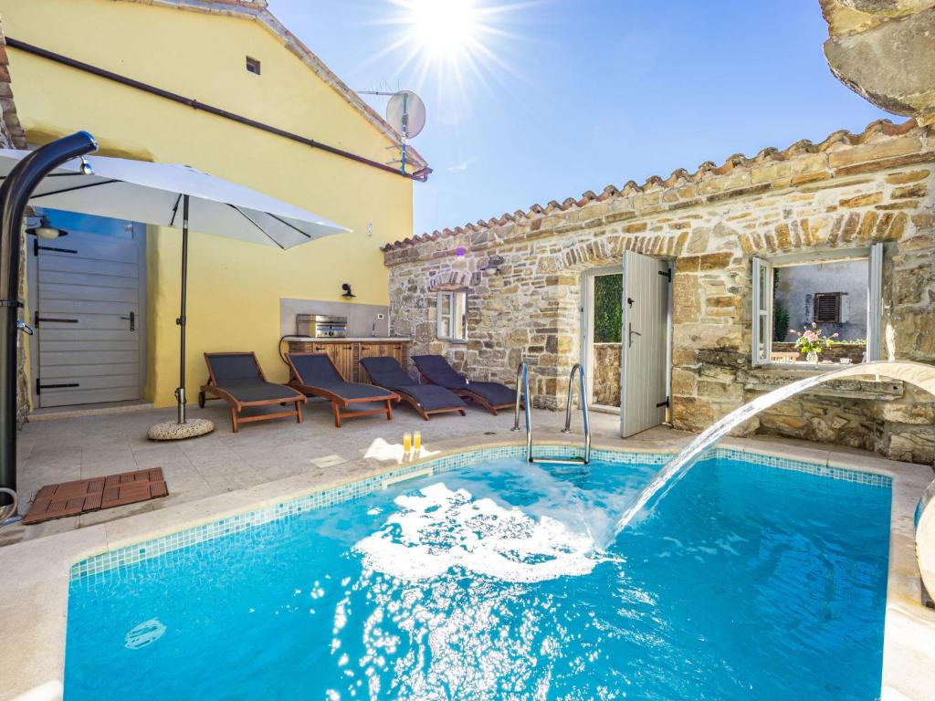 een zwembad met een waterpartij in een tuin bij Holiday Home Franz by Interhome in Potpićan