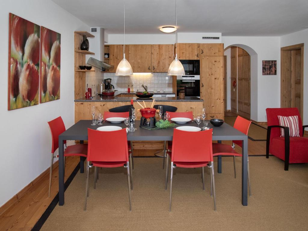 a dining room with a table and red chairs at Apartment Les Combins 30 by Interhome in Champex