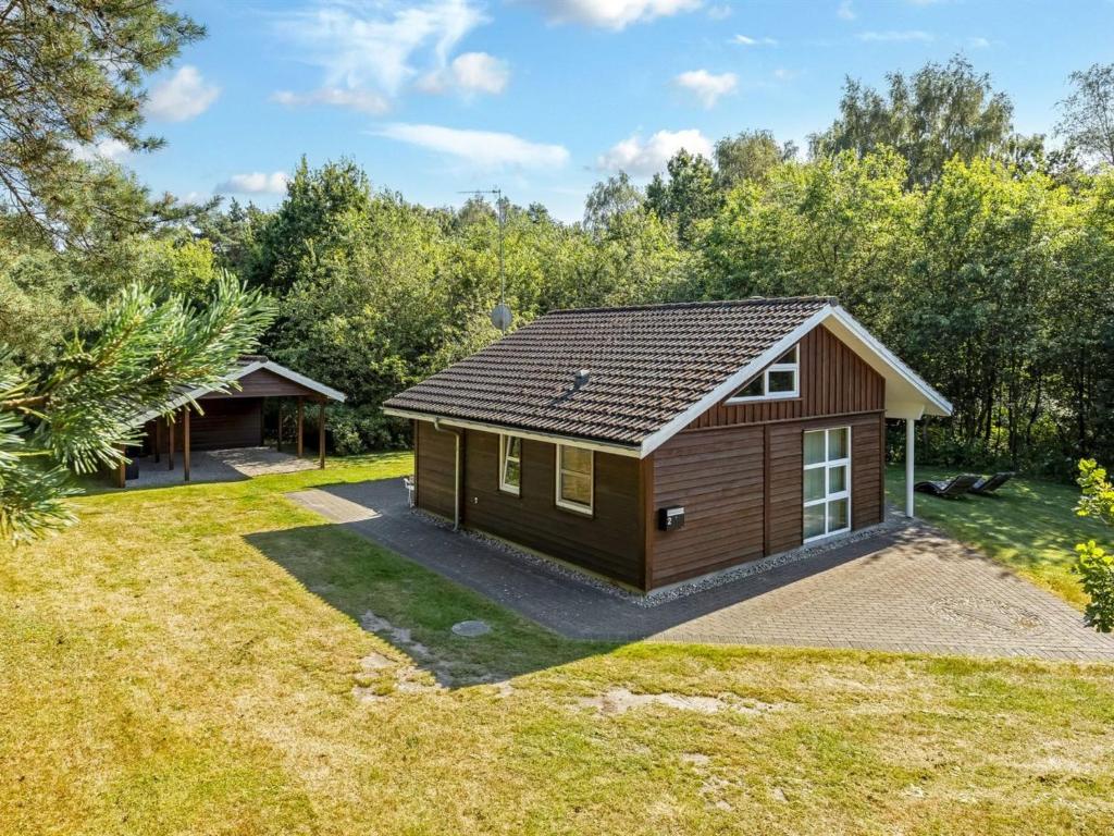 een kleine hut in een tuin met bomen bij Holiday Home Angantir - 4-8km from the sea by Interhome in Byrum