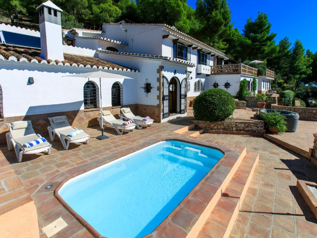 a villa with a swimming pool in front of a house at Holiday Home El Comendador by Interhome in Acebuchal