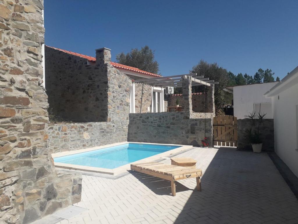 a backyard with a pool and a bench and a house at Casas da Lameirancha in Mação