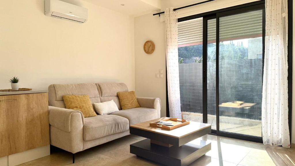 a living room with a couch and a table at Centrale climatisée deux chambres terrasse parking, saint raphael in Saint-Raphaël