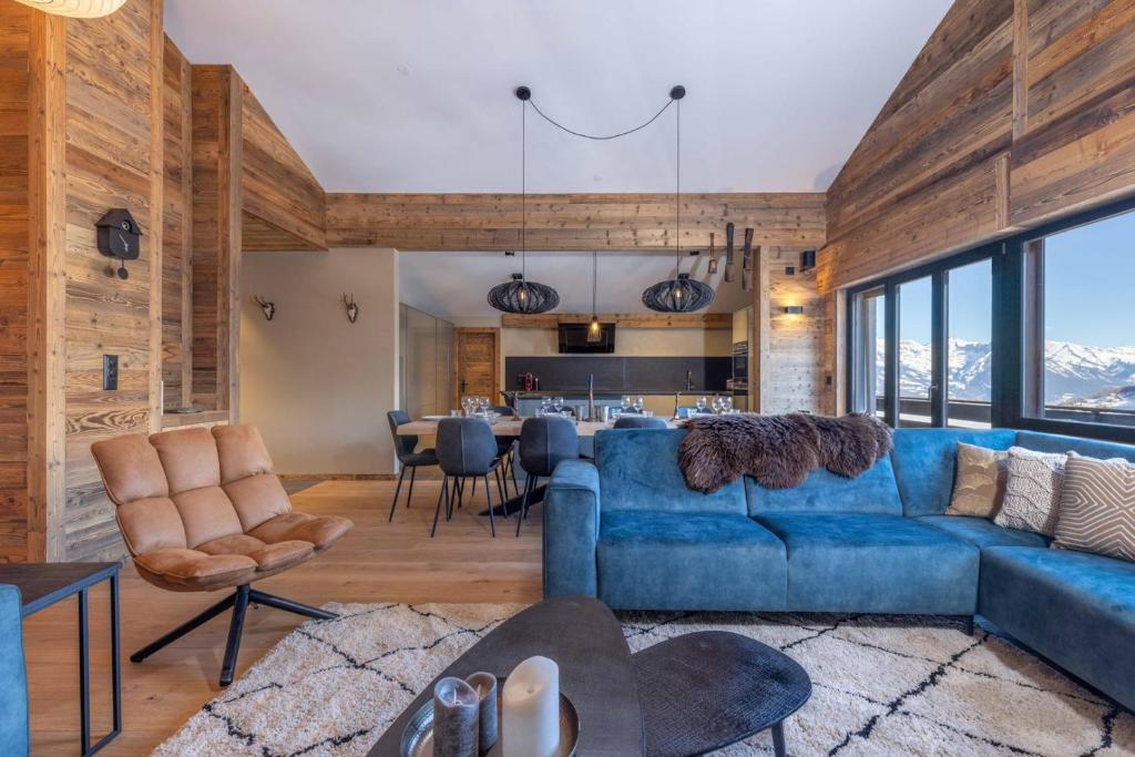 a living room with a blue couch and a table at Penthouse Croix de Coeur in Riddes
