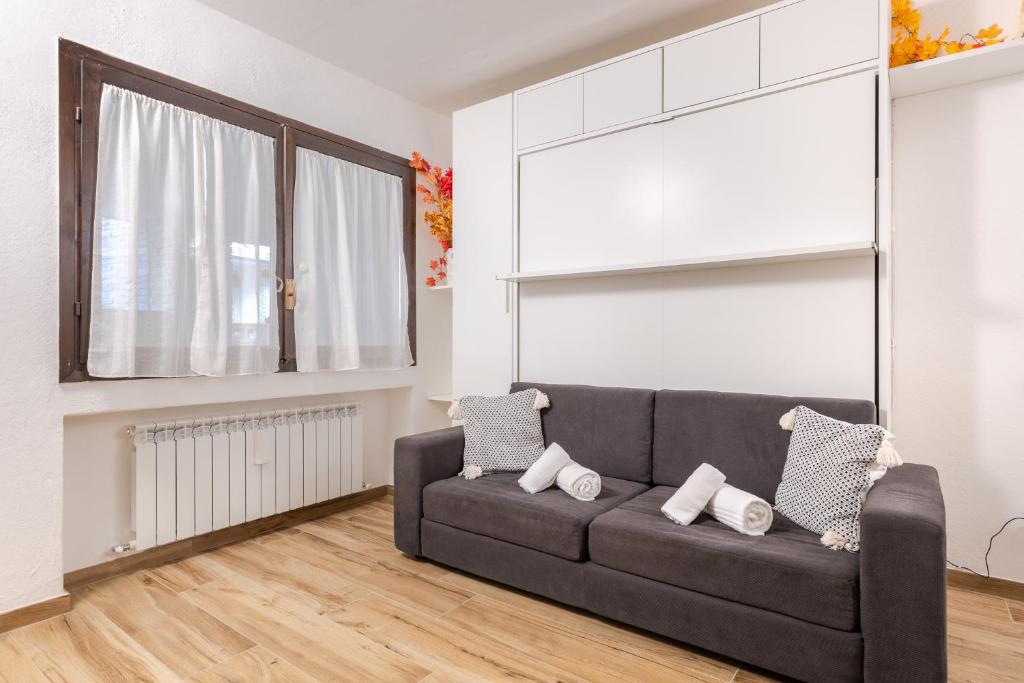 a living room with a couch and a window at Hostdomus - Valle Studio in Grange Sises